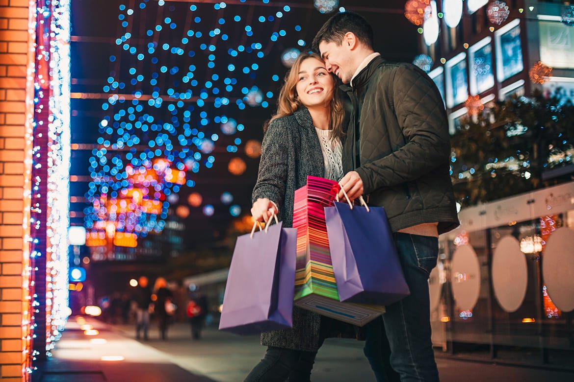 happy couple with shopping bags enjoying night city