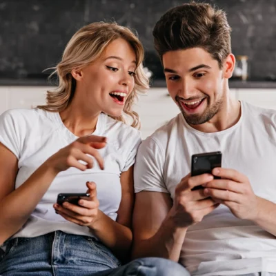 smiling couple sitting couch with phones