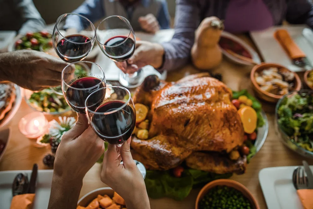 people toasting with wine at Thanksgiving dinner